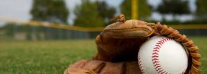 Baseball glove holding baseball on field